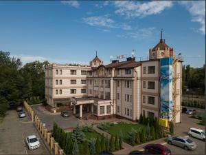 un gran edificio con coches estacionados en un estacionamiento en Slava Hotel, en Zaporozhye