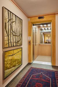 a hallway with a door with a rug and a painting at Garni Karin in Corvara in Badia