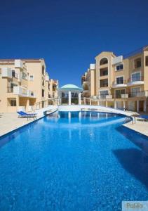 a large blue swimming pool in front of some buildings at Mia's Cove in Paphos