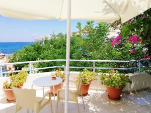 a patio with a table and chairs and an umbrella at Seafront Studios and Apartments in Chios