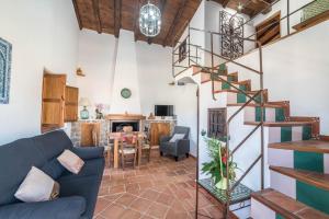 ein Wohnzimmer mit einer Wendeltreppe in einem Haus in der Unterkunft Al Agia - Mirador de los Quinientos in Padul