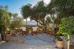 a patio with a table and chairs under a tree at Elysium in Glinádhon