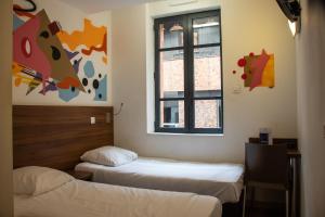 Postel nebo postele na pokoji v ubytování Hôtel le Pastel