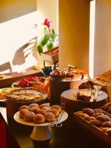 un buffet con muchos tipos diferentes de pasteles y tartas en Hotel Cir, en Selva di Val Gardena