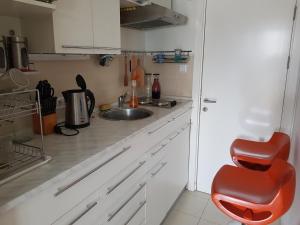 a small kitchen with a sink and a red chair at Lav apartments in Banja Luka