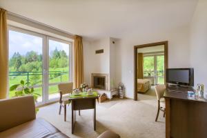 un salon avec une grande fenêtre et une télévision dans l'établissement 4 Pory Roku & Spa, à Krynica-Zdrój