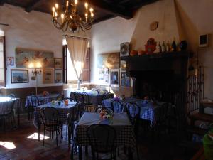 a dining room with blue tables and chairs and a fireplace at Civita B&B in Bagnoregio