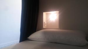 a bedroom with a bed with a light in a window at R4Hostel in Vigo