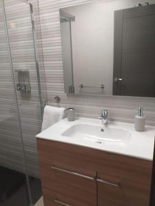 y baño con lavabo y ducha con espejo. en Apartamentos Vacacionales Joctis, Bajo B, en Fuengirola