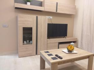 sala de estar con TV y mesa de centro en Apartamentos Vacacionales Joctis, Bajo B, en Fuengirola