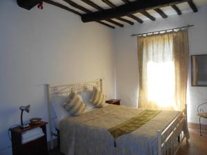 a bedroom with a large bed and a window at Civita B&B in Bagnoregio