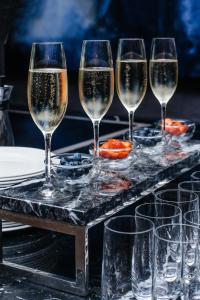 una bandeja con cuatro copas de champán en una mesa en Crystal House Suite Hotel & SPA en Kaliningrado