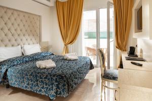 a bedroom with a bed with two towels on it at Hotel Ambassador in Rimini