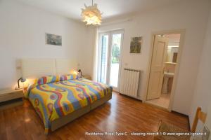 a bedroom with a bed with a colorful comforter at Villa a Lignano Pineta in Lignano Sabbiadoro +51 photos