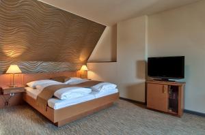 ein Schlafzimmer mit Bett und Flachbildfernseher in der Unterkunft Club Hotel Cortina in Wien