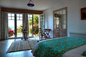 a bedroom with a bed and a view of the ocean at Chambres d'hôtes Les 4 Vents Pointe du Hoc - Landing Beaches in Grandcamp-Maisy +30 photos