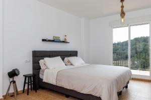 ガータ・デ・ゴルゴスにあるVilla Costa Blancaのベッドルーム1室(白いシーツ付きのベッド1台、窓付)
