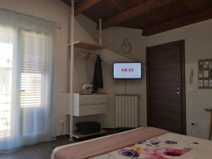 1 dormitorio con 1 cama y TV en la pared en Canale rooms e apartments, en Casteldaccia