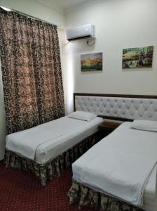 a hotel room with two beds and a window at Hotel "GRAND WAY" in Tashkent