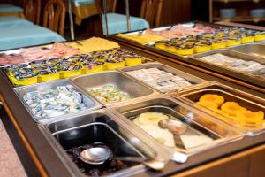 una línea de buffet con muchos tipos diferentes de comida en Hotel Alpe, en Canazei