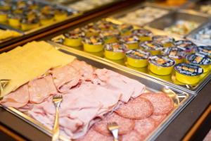 uma vitrine com diferentes tipos de carnes e queijos em Hotel Alpe em Canazei