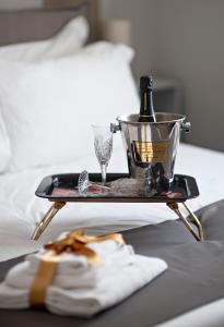 a tray with a bottle and glasses on a bed at Il Genovino in Genoa