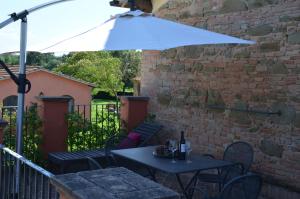 - une table et des chaises sous un parasol sur la terrasse dans l'établissement Country House Le Case Coloniche, à Deruta