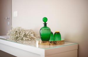 two green glass vases sitting on top of a dresser at Il Genovino in Genoa