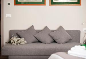 a gray couch with four pillows in a living room at Il Genovino in Genoa