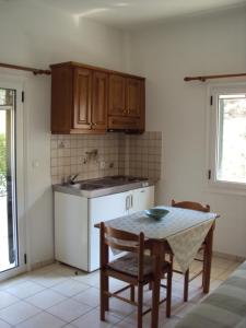 a kitchen with a table and a table and chairs at Yasemi Rooms in Vasiliki