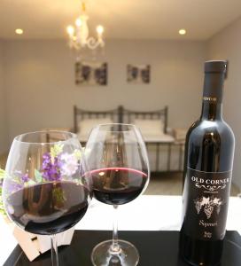 dwa kieliszki czerwonego wina obok butelki wina w obiekcie OLD CORNER w mieście Tbilisi City