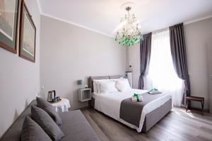 a bedroom with a bed and a couch and a chandelier at Il Genovino in Genoa