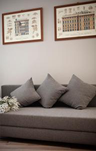 a couch with four pillows on it in a living room at Il Genovino in Genoa