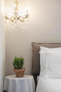 a chandelier with a plant on a table next to a bed at Il Genovino in Genoa