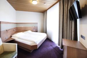 a bedroom with a bed and a tv in it at Hotel Rieth in Böblingen
