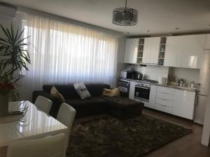 Una sala de estar con un sofá y una cocina. en Pipera Lake View by ACME RENT, en Bucarest