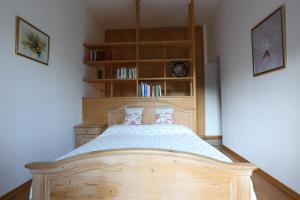 a bedroom with a wooden bed and a book shelf at Spazioso e accogliente nel centro di Merano in Merano