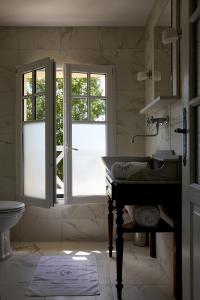 uma casa de banho com um lavatório e 2 janelas em Chambres d'hôtes Les 4 Vents Pointe du Hoc - Landing Beaches em Grandcamp-Maisy