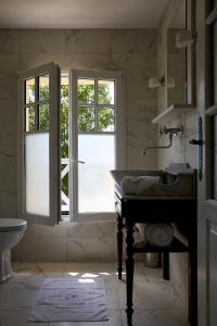 a bathroom with a sink and two windows at Chambres d'hôtes Les 4 Vents Pointe du Hoc - Landing Beaches in Grandcamp-Maisy