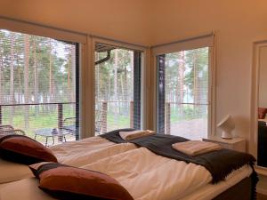 a bedroom with a bed and two large windows at Kustavin Lootholma in Kustavi