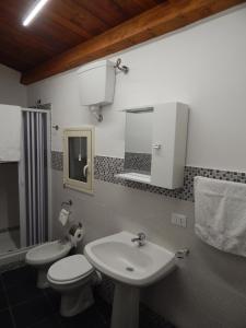 y baño con lavabo, aseo y espejo. en Canale rooms e apartments, en Casteldaccia