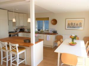 a kitchen and dining room with a table and chairs at Pevensey Beach Retreat in Pevensey