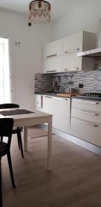 a kitchen with white cabinets and a table in a room at Da Emi E Giuly in Mestre