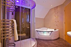 a bathroom with a bath tub, toilet and sink at Standing Stones Hotel in Stromness