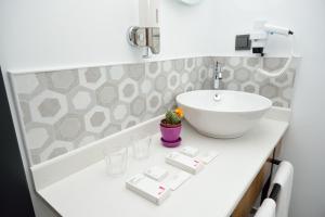a bathroom with a sink and a white bowl sink at Hotel Adora in Tbilisi City