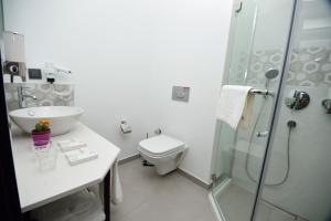 a bathroom with a toilet and a sink and a shower at Hotel Adora in Tbilisi City