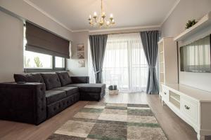een woonkamer met een bank en een televisie bij ByTheSea Superior Apartments in Mamaia