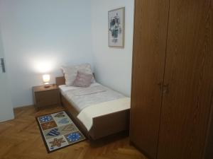 - une petite chambre avec un lit et une table de nuit dans l'établissement Apartman Sanja, à Rovinj