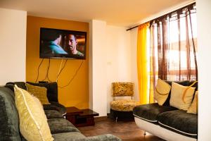Home Café- Apartahotel في مونتينيغرو: غرفة معيشة مع كنبتين وتلفزيون بشاشة مسطحة
