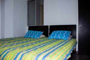 Una cama con dos almohadas azules encima. en Home Café- Apartahotel, en Montenegro